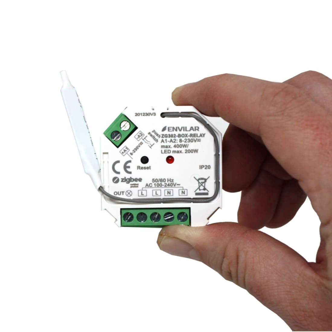 Zigbee relä 3.0 i kompakt vit kapsling med gröna anslutningar, hålls i en hand, kompatibelt med Philips Hue och Apple Homekit.