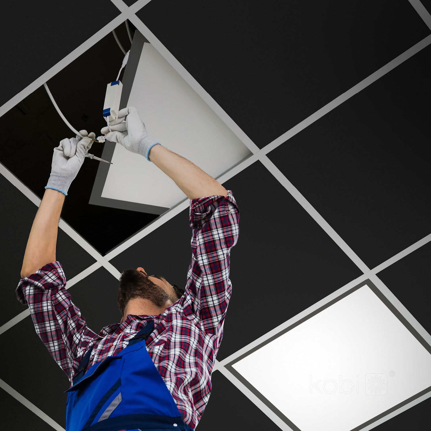 Elektriker installerar LED Panel 60x60 med svart ram i en takkonstruktion. Panelen på 40W och 4000K ansluts via driver för effektiv inomhusbelysning.