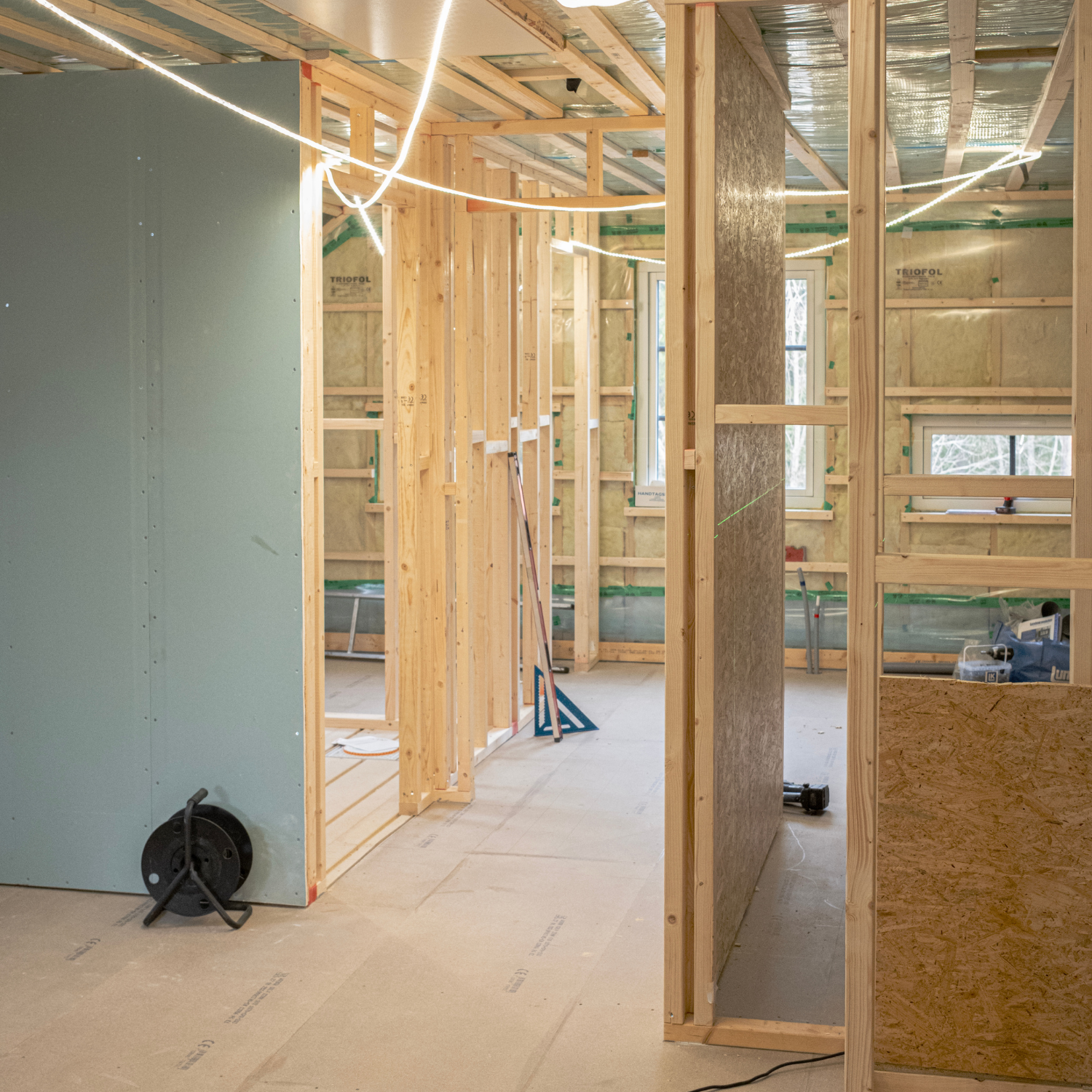 LED ljusband monterat i ett husbygge, längs väggar och tak för jämn arbetsbelysning.